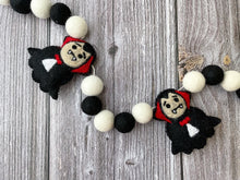 Load image into Gallery viewer, Dracula Halloween Garland. Halloween Decor made with black and white  felt pom poms and felted Draculas.
